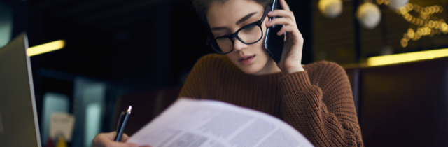 Woman reviewing personal bankruptcy paperwork while talking on cell phone